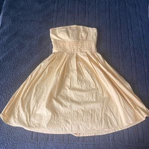 Short, yellow, strapless dress.